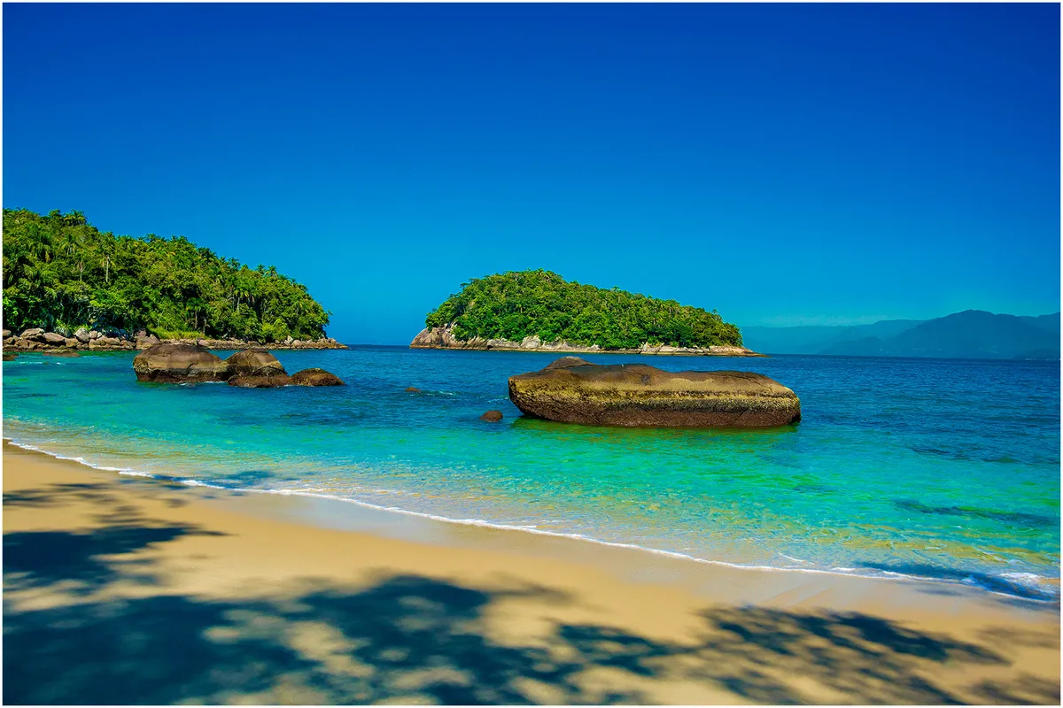 Ilha das Couves em Ubatuba com água cristalina e rochas durante passeio de lancha