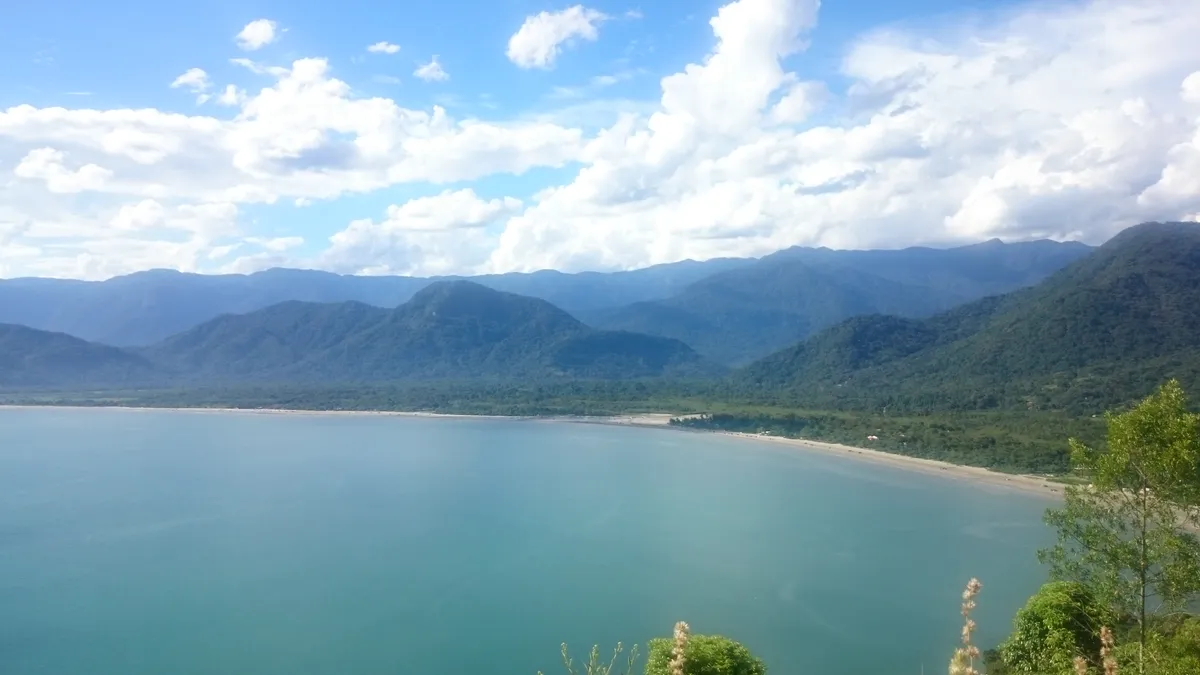 Vista panorâmica da Praia da Almada em Ubatuba com serra e mar azul, parada de almoço do passeio de lancha