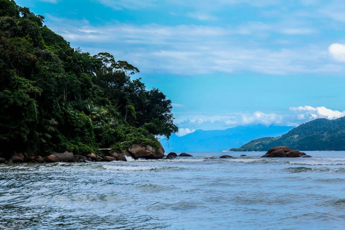 Costão de pedras e Mata Atlântica na Praia da Lagoinha em Ubatuba, com a Serra do Mar ao fundo