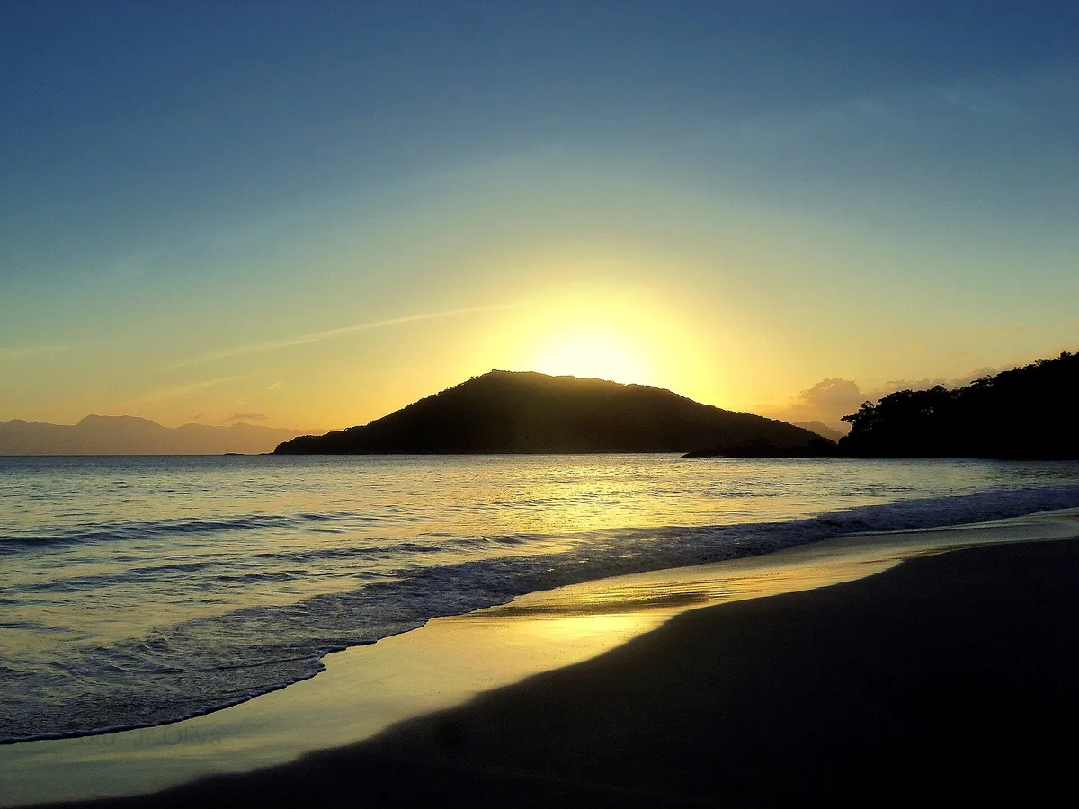 Pôr do sol na Praia do Itaguá, em Ubatuba, onde fica a orla com restaurantes de frente para o mar